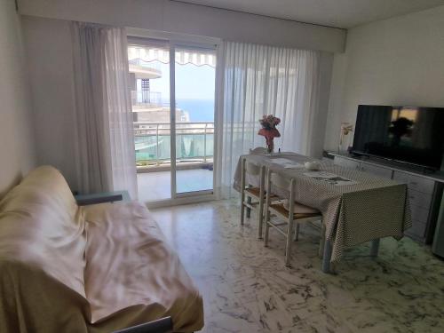 a living room with a dining table and a television at 1 meter from Monaco. 5 min by elevators to Larvotto beach. in Beausoleil