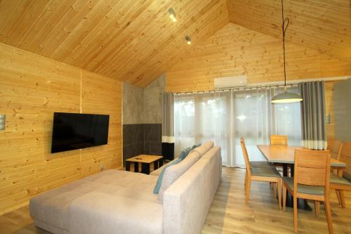 uma sala de estar com uma cama e uma sala de jantar em Eko-domki w Krynica Morska-Piaski em Nowa Karczma