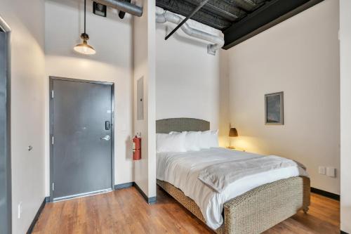 a bedroom with a large bed and a glass door at Hoppy Hideaway: Coastal Loft with a Brewery Twist in Myrtle Beach