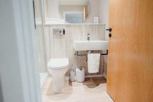 a bathroom with a white toilet and a sink at The Dunes in Tenby