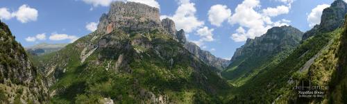 a view of a mountain range with clouds in the sky at Hotel Ladias in Monodendri