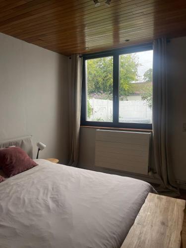 een slaapkamer met een groot bed en een raam bij Ingerichte woning met tuin in Leuven