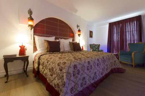 a bedroom with a large bed and a table and chair at Cella Hotel & SPA Ephesus in Selcuk