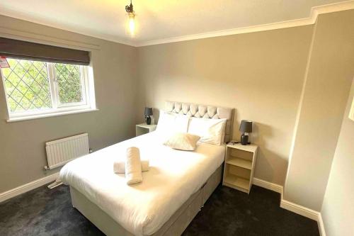 Canford MagnaにあるThe Spacious & Luxury 'Grey Goose' Home, Bournemouth, Dorsetのベッドルーム(大きな白いベッド1台、窓付)