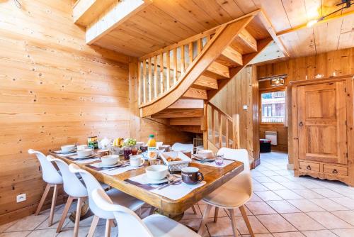 un comedor con una mesa larga y sillas blancas en GRANGE 3, en Morzine
