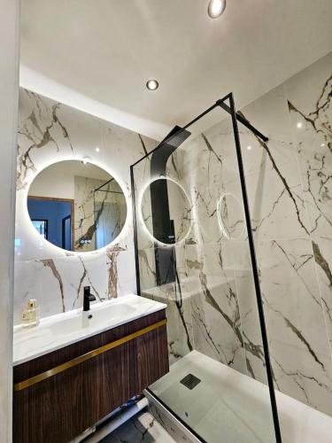 une salle de bain avec un lavabo et un miroir dans l'établissement Stylish rooftop avec terrasse à 2pas de Disney Paris, à Montévrain