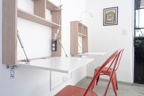 eine Küche mit einer weißen Theke und einem roten Stuhl in der Unterkunft PH Palermo Hostel in Buenos Aires