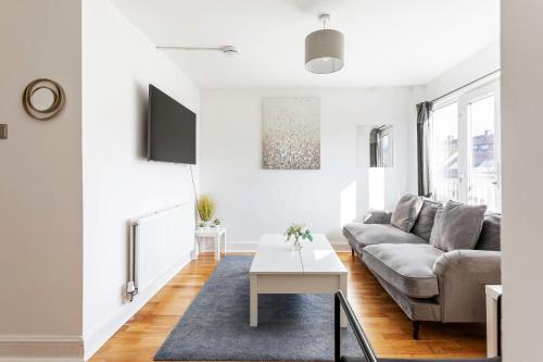 a living room with a couch and a table at Modern Home Near Central London in London