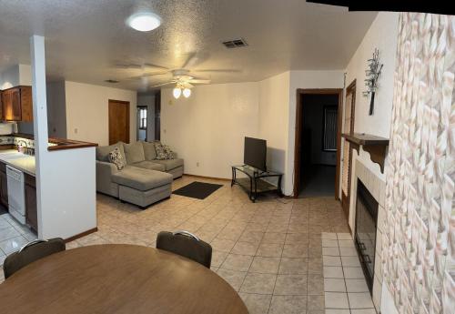a living room with a couch and a table at Townhouse, two car garage, fireplace back yard in Las Cruces