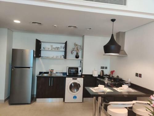 a kitchen with a washer and a table with chairs at Apartment number 365 Era View in Manama