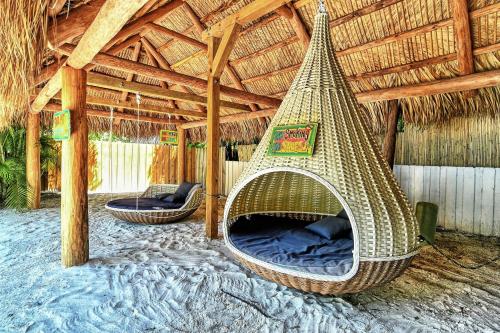 a hammock in a straw hut with a bed at Siesta Key Palms Resort in Sarasota