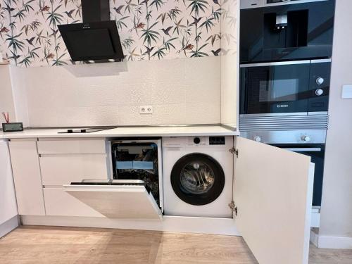 a washer and dryer in a kitchen with a microwave at AdriVA Apartamento-Loft Imperial centro WIFI in Valladolid