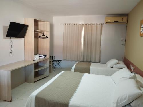 Una habitación de hotel con dos camas y un televisor. en Gurgueia Park Hotel, en Cristino Castro