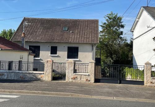 Biały dom z bramą i płotem w obiekcie Maison calme proche zoo beauval et chateaux de la loire w mieście Contres