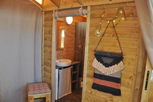 a bathroom with a sink and a mirror and a towel at Flower Camping Au Bois des Biches in Saint-Hilaire-de-Riez