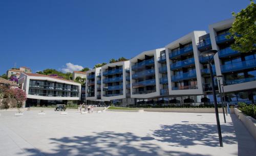 un gran edificio de apartamentos con gente parada frente a él en Maistra Select Mlini Hotel, en Mlini