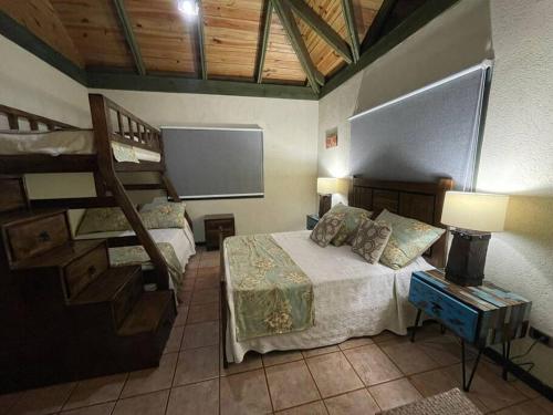 1 dormitorio con 2 literas y TV de pantalla plana en Villa las Tres Marias 24 personas chef incluido en Jarabacoa
