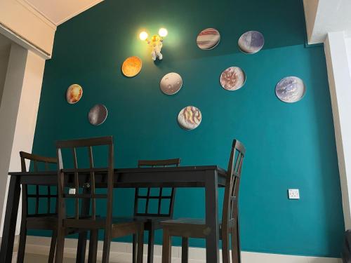 a dining room table with planets on a green wall at Green Space Homestay Cozy Family(8-12pax) in Ipoh