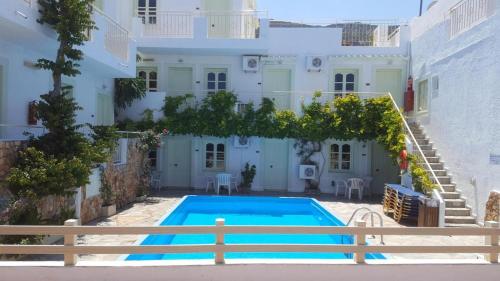 a swimming pool in front of a white house at Optasia Apartments in Hersonissos