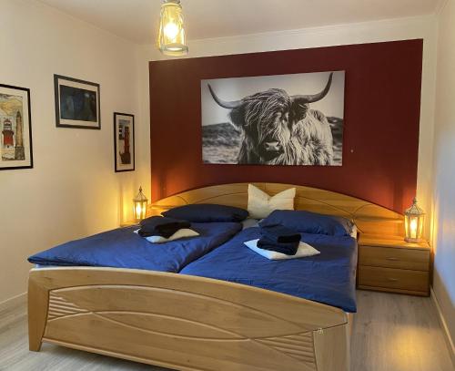 1 dormitorio con 1 cama con una foto de toro en la pared en Haus Sansibar Niendorf, en Timmendorfer Strand