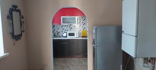 une cuisine avec une arche menant à une cuisine équipée d'un réfrigérateur dans l'établissement вулиця Нагiрна, à Kamianets-Podilsky
