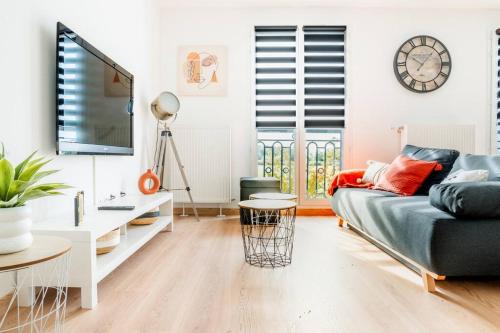 un salon avec un canapé et une télévision dans l'établissement Charme proche Disneyland Paris, à Serris