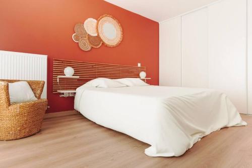- une chambre avec un lit blanc et un mur rouge dans l'établissement Charme proche Disneyland Paris, à Serris