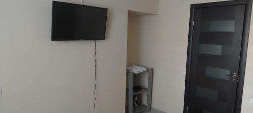 Une télévision à écran plat est installée sur un mur à côté d'une porte. dans l'établissement вулиця Нагiрна, à Kamianets-Podilsky