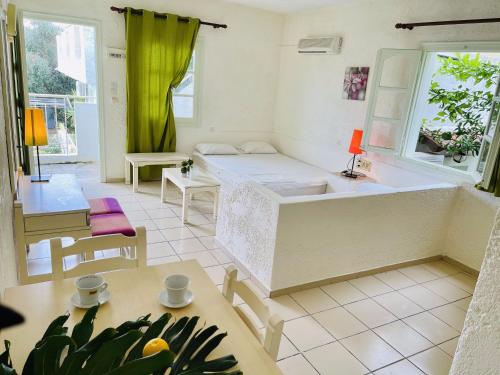 Zimmer mit einem Bett, einem Tisch und Stühlen in der Unterkunft Optasia Apartments in Hersonissos