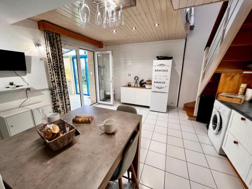 a kitchen with a table with chairs and a counter top at Keraven, charmante maisonnette, piscine commune 1-4 personnes in Moëlan-sur-Mer