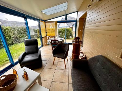a living room with a couch and chairs and a table at Keraven, charmante maisonnette, piscine commune 1-4 personnes in Moëlan-sur-Mer