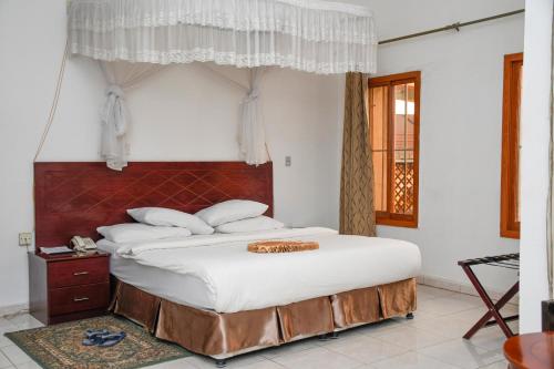 a bedroom with a large bed with white sheets at Aron International Hotel in Juba