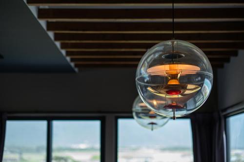 a glass chandelier hanging from a ceiling with windows at 發現七星潭海景民宿 in Dahan