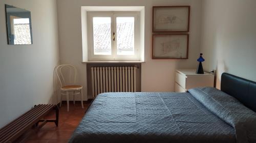 a bedroom with a bed and a window and a chair at Al Ponte di Tiberio in Rimini