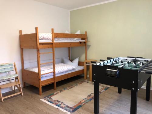 a room with bunk beds and a foosball table at Harzquerbahnblick in Benneckenstein