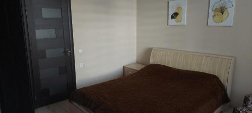 - une chambre avec un lit et une couverture brune dans l'établissement вулиця Нагiрна, à Kamianets-Podilsky