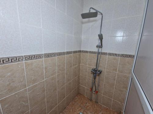 een douche met een douchekop in de badkamer bij Гостиница-хостел Дастур 