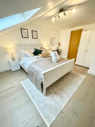 a bedroom with a white bed and a white rug at Luxury en-suite double bedroom Stratford E15 in London