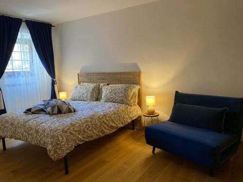 a bedroom with a bed and a blue chair at ORVIETO ANTICA Apartment in Orvieto