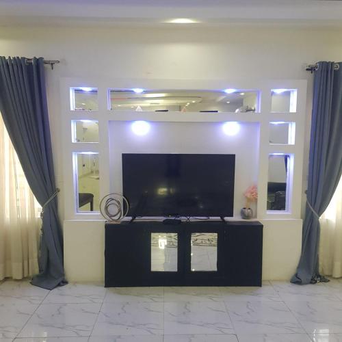 uma sala de estar com uma grande televisão de ecrã plano em SURPRISE PALACE em Ibadan