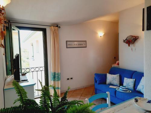 salon z niebieską kanapą i balkonem w obiekcie La Residenza del Porto w mieście Santa Teresa Gallura