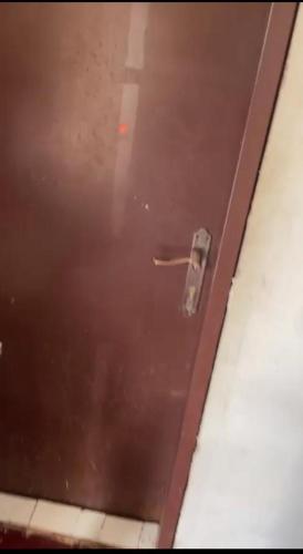 uma porta castanha com uma maçaneta num quarto em غرفة سائق للايجار مؤثثه مكيف و مفروشة ثلاجة وسرير em Riyadh