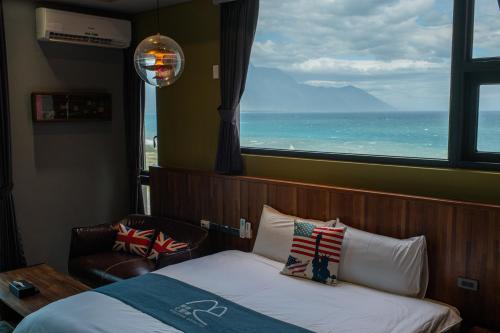 a bedroom with a bed and a window with the ocean at 發現七星潭海景民宿 in Dahan