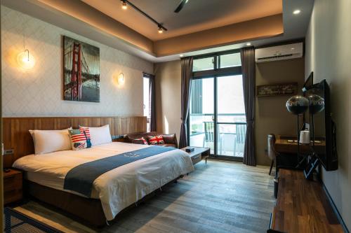 a bedroom with a bed and a desk and a window at 發現七星潭海景民宿 in Dahan