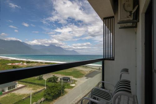 a balcony with chairs and a view of the ocean at 發現七星潭海景民宿 in Dahan