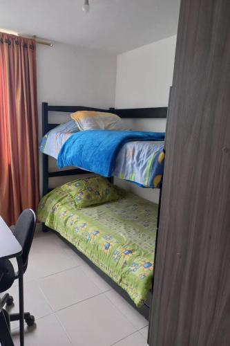 1 dormitorio con 2 literas y 1 silla en Apartamento hogareño, en Pereira