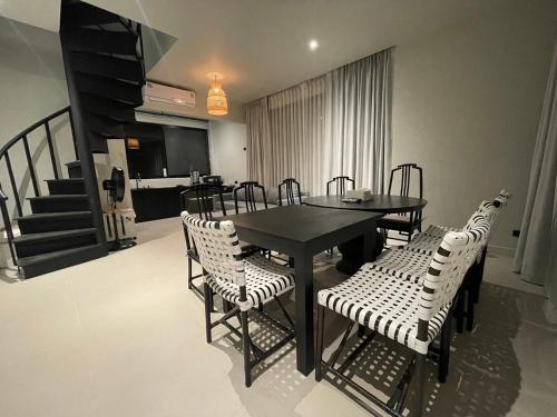 uma sala de jantar com uma mesa e cadeiras e uma escadaria em O2 The Residence โอทู เดอะ เรสซิเดนซ์ em Kanchanaburi