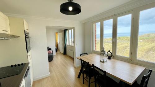 Il comprend une cuisine et une salle à manger avec une table et des chaises. dans l'établissement Appartement Cocoon - Face mer - Stella-Plage, à Stella-Plage