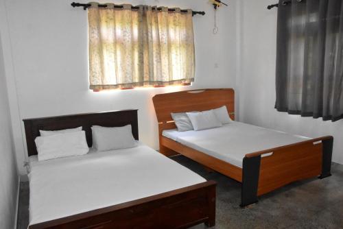 - 2 lits dans une petite chambre avec fenêtre dans l'établissement Camellia Resort, à Anurâdhapura