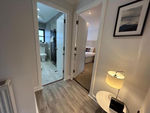 a room with a hallway with a table and a lamp at Principal Apartments - Merchant City in Glasgow